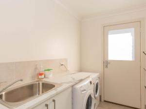 a kitchen with a sink and a washing machine at Jindalee 1 11 Twynam Street in Jindabyne