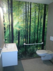 a bathroom with a mural of a forest at Hotel Boerderij Restaurant De Gloepe in Diffelen