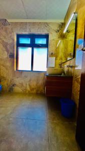 La salle de bains est pourvue d'un lavabo et d'une fenêtre. dans l'établissement Hotel de borgo, à Leh