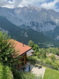 una casa con techo rojo con montañas al fondo en Chalet familial, en Chamoson