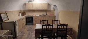 POLLY FOURNAROU tower-house في Miléa: مطبخ مع طاولة وكراسي في غرفة