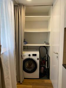 una lavatrice e asciugatrice in una piccola stanza con di Studio de luxe, au coeur de la vieille ville a Sion