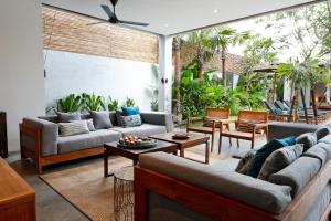 an outdoor living room with couches and tables at Villa Ziba in Seminyak