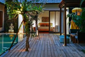 a house with a pool and a bedroom with a bed at Villa Ziba in Seminyak