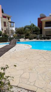 a stone walkway next to a swimming pool at Apartament Cosy House with pool, Paphos Pafos,Tombs of Kings in Paphos