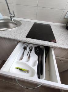 a kitchen counter with a sink with tools in it at Atmosfera - Студия в новом доме в центре города in Lipetsk