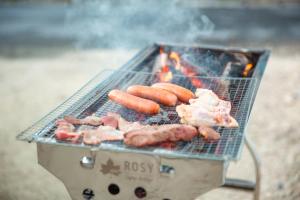 a grill with meat and sausages cooking on it at Sunnyside in Miyako Island