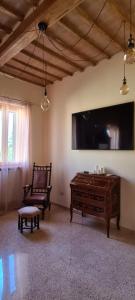 a living room with a large flat screen tv and a bench at Il Nido del Cuculo in Petrignano