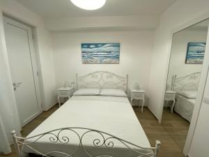 un letto bianco in una stanza con due tavoli di Amare il Mare a Polignano a Mare