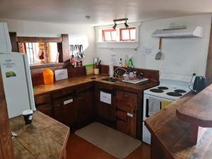 a kitchen with wooden cabinets and a stove top oven at Rusty Nail Backpackers in Taihape