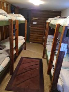 Zimmer mit 4 Etagenbetten und einem Teppich in der Unterkunft Rusty Nail Backpackers in Taihape