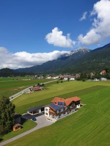 a house in a field with mountains in the background at Haus Hämmerle in Reutte