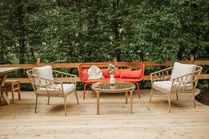 a patio with a red couch and two chairs and a table at Bio-Landpension Monika in Leutasch