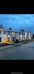 un gran edificio blanco con una calle delante en 23-hotel en Schwadorf