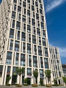 a tall white building with trees in front of it at New 3 rooms apartment near the metro station in Kyiv