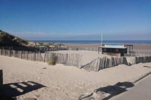 a fence on a beach with a volleyball court at Home sweet home en Bord de Mer in Camiers