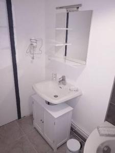 a white bathroom with a sink and a toilet at Home sweet home en Bord de Mer in Camiers
