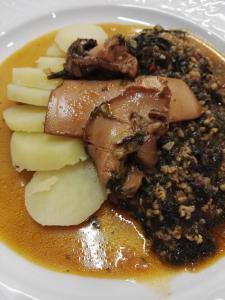 un plato de comida con carne y manzanas y salsa en Viraggas Traditional hotel, en Vrástama