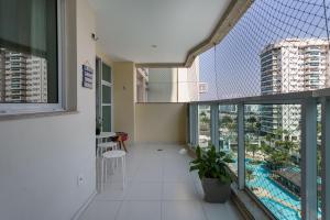 a room with a balcony with a view of a building at Bora Bora Resort Barra da Tijuca in Rio de Janeiro