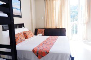 a bedroom with a bed with an orange blanket on it at Miranda A 609 Pico De Loro Beach and country club by SEE condominium rentals in Nasugbu