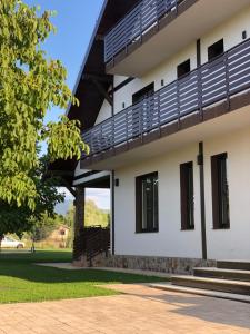 a building with a balcony on the side of it at Pensiunea Trecatoarea Lupilor in Burda