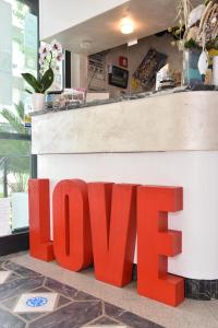 Un cartello che dice amore seduto davanti a un negozio di Hotel Nuovo Giardino a Rimini