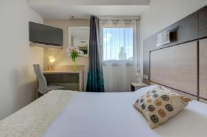 a hotel room with a bed and a desk and a window at Eurotel Parc Expo Airport Montpellier in Pérols +67 photos