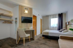 a hotel room with a bed and a desk and a tv at Eurotel Parc Expo Airport Montpellier in Pérols