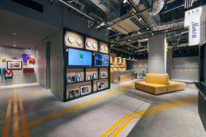a room with a yellow chair and a tv at ibis Styles Nagoya in Nagoya