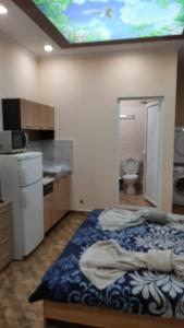 a room with a bed and a kitchen with a tv on the ceiling at АРт 1 in Sliven