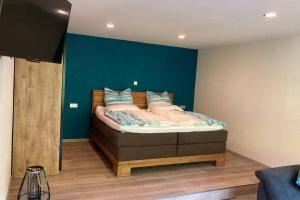 Schlafzimmer mit einem Bett mit blauer Wand in der Unterkunft Dinkel Haus an der Mosel in Traben-Trarbach