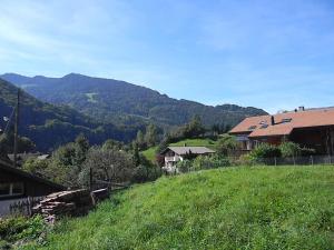 einen grünen Hügel mit Häusern und Bergen im Hintergrund in der Unterkunft Dorner Rustic Chalet in Gsteigwiler