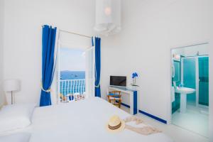 a bedroom with a bed and a window with the ocean at Laurito Beach Cucina & Camere in Positano