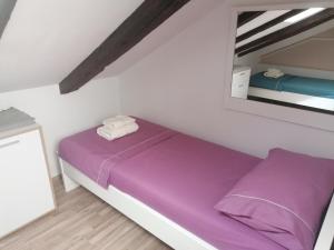 een slaapkamer met een paars bed en een spiegel bij Holiday House Tina in Pula