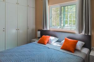 a bedroom with a blue bed with two orange pillows at Monte Mare Rhodes in Ixia