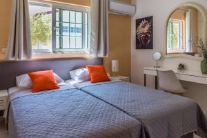 una camera da letto con letto blu e cuscini arancioni di Monte Mare Rhodes a Ixiá
