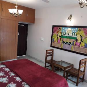 een slaapkamer met een bed en een tafel en een schilderij aan de muur bij Jaipur Sundeck in Jaipur