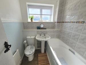 a bathroom with a toilet and a sink and a bath tub at Welo House - Home from Home in Teynham