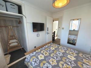 a bedroom with a bed and a flat screen tv at Welo House - Home from Home in Teynham