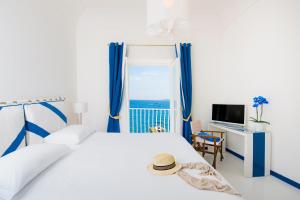 a bedroom with a bed with blue curtains and a window at Laurito Beach Cucina & Camere in Positano