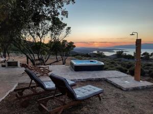 a couple of chairs and a hot tub on a patio at Villa Humac Hvar in Poljica