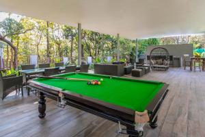 a pool table in the middle of a room at Reflection House by StayVista with Pool, Terrace bar, Indoor games & Exquisite interiors in a nutshell in Alibaug