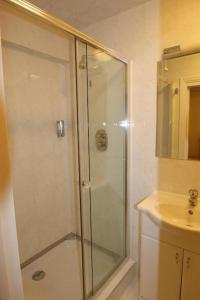 
a bathroom with a shower, sink, and toilet at Abbey Court Hotel - Hyde Park in London
