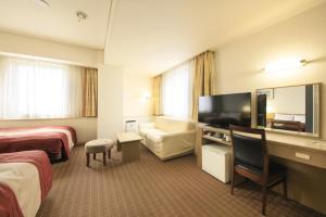 a hotel room with two beds and a flat screen tv at Hotel Nagano Avenue in Nagano +55 photos
