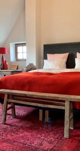 1 dormitorio con 1 cama grande con manta roja en b&b Meilrijk en Diest