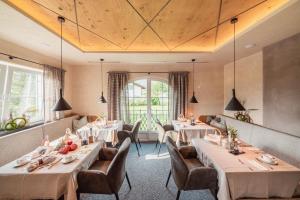 un ristorante con tavoli e sedie in una stanza di MONS suites wine passion a Tannheim