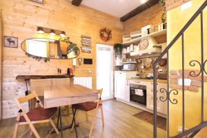 una cucina con pareti in legno e tavolo e sedie in legno di Nido dell'Aquila - Appartamento in Milano Porta Romana a Milano