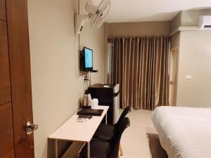a hotel room with a desk and a bed at Kangaroo Residence Udonthani in Udon Thani