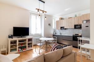 een woonkamer met een bank en een tafel en een keuken bij Cosy 1-bed near Milano Centrale in Milaan