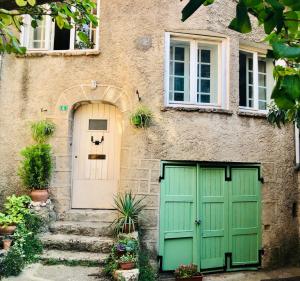 a house with a green door and stairs at La Chambre Rose-Maison Searle à Tourtour in Tourtour